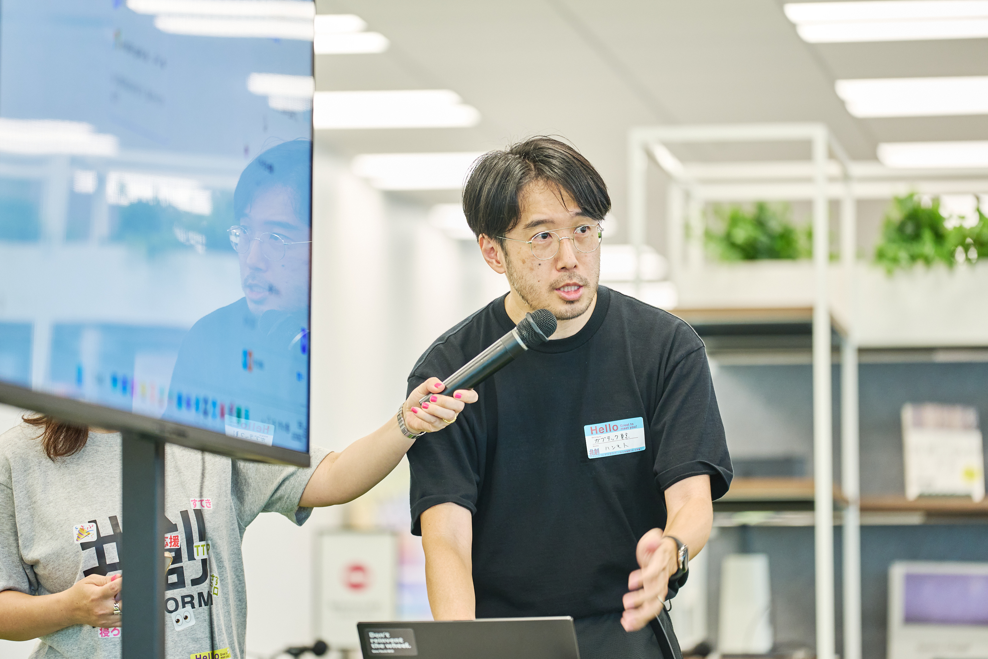 GovTech東京の橋本淳一氏がモニターにつないだパソコンを操作しながら話している様子を正面から撮影。