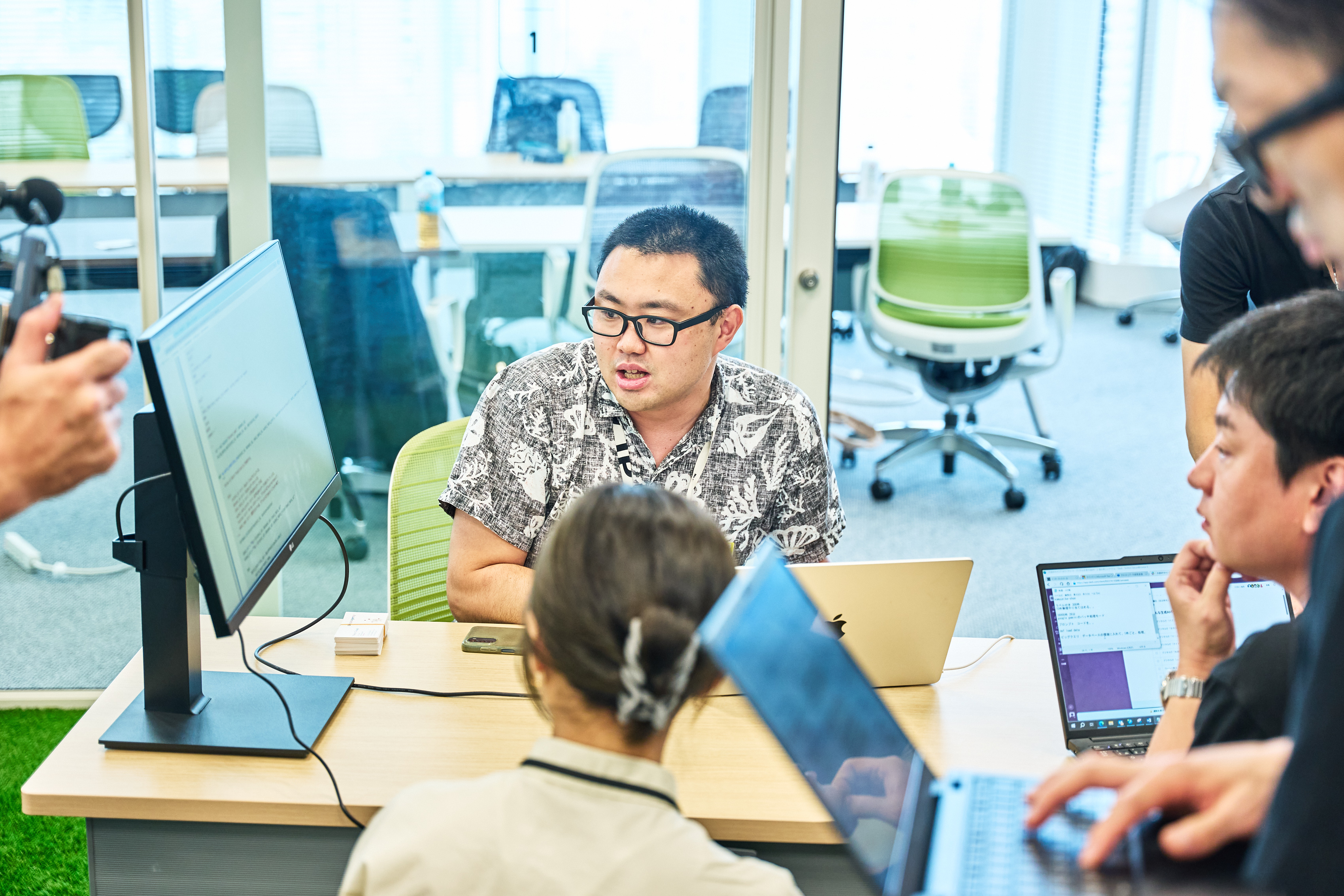 デジタル庁の大杉がモニターを見ながら、ハンズオン形式でAIツールをデモンストレーションしながら、参加者の疑問・質問に対応している様子。