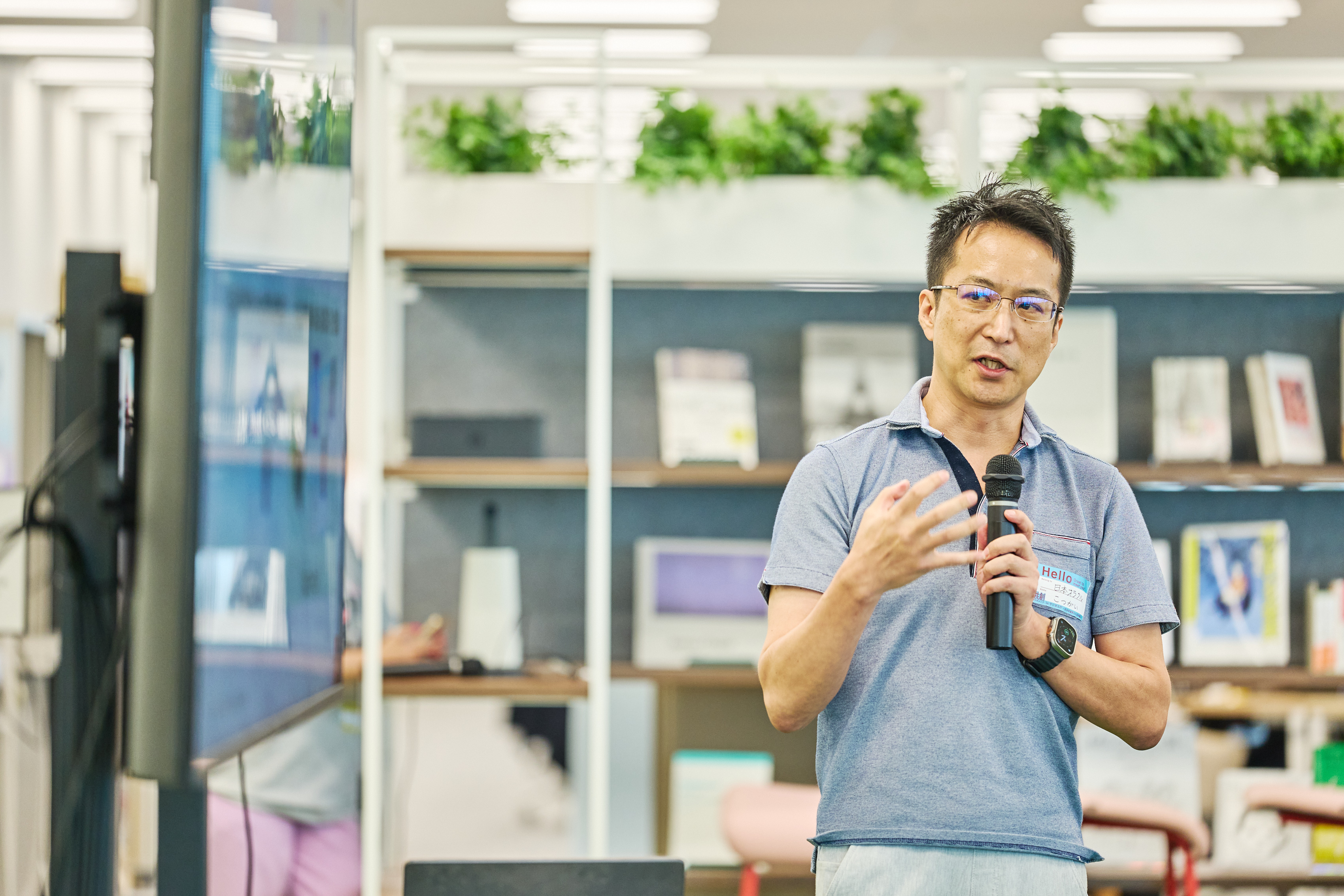 日本オラクル株式会社の小番弘久氏が登壇してモニター前で話している様子を正面から撮影している。