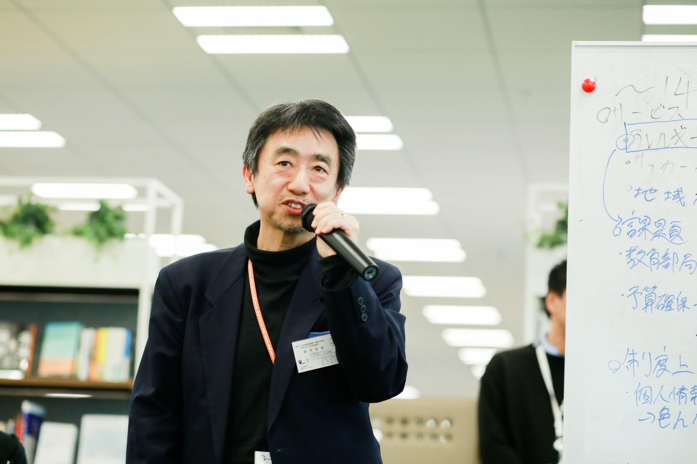 東京都調布市 行政経営部 鈴木 宏昌氏がマイクを使って説明している様子