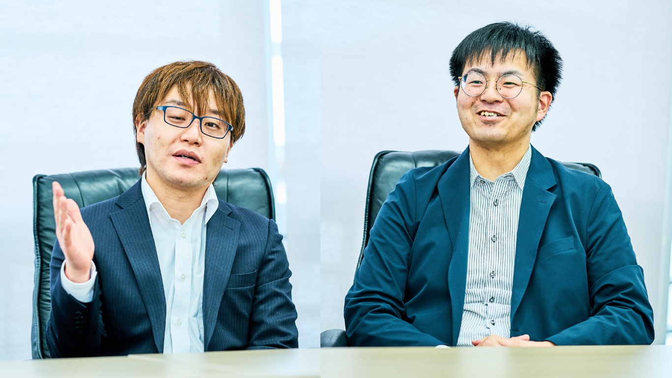 利府町上下水道課の佐藤主任（左）と大平主事が着席しインタビューに応じている様子。佐藤主任は手振りをつけながら話している。