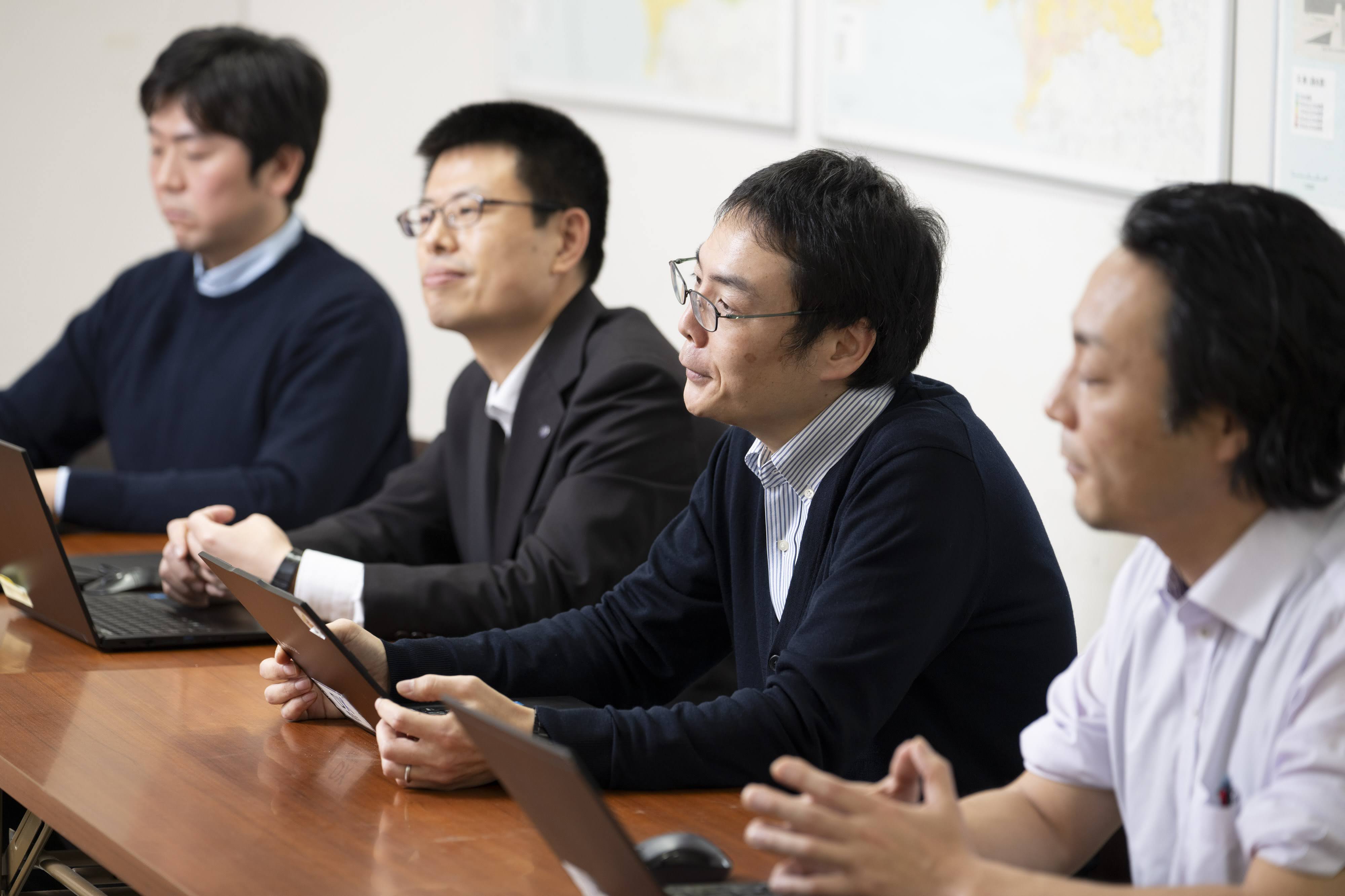 木製の長テーブルに、和歌山市職員が横並びに座っている。手元にはノートパソコンが置かれている。