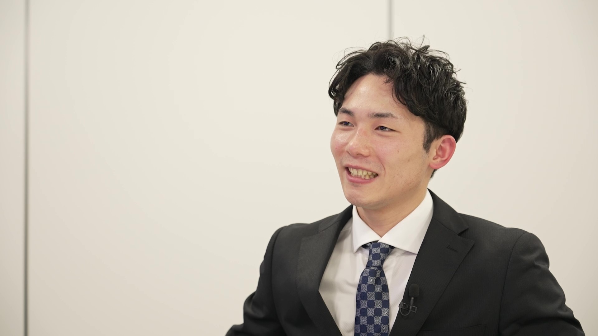 インタビューを受ける中野区戸籍住民課の岸田主事を正面右手から撮影している。