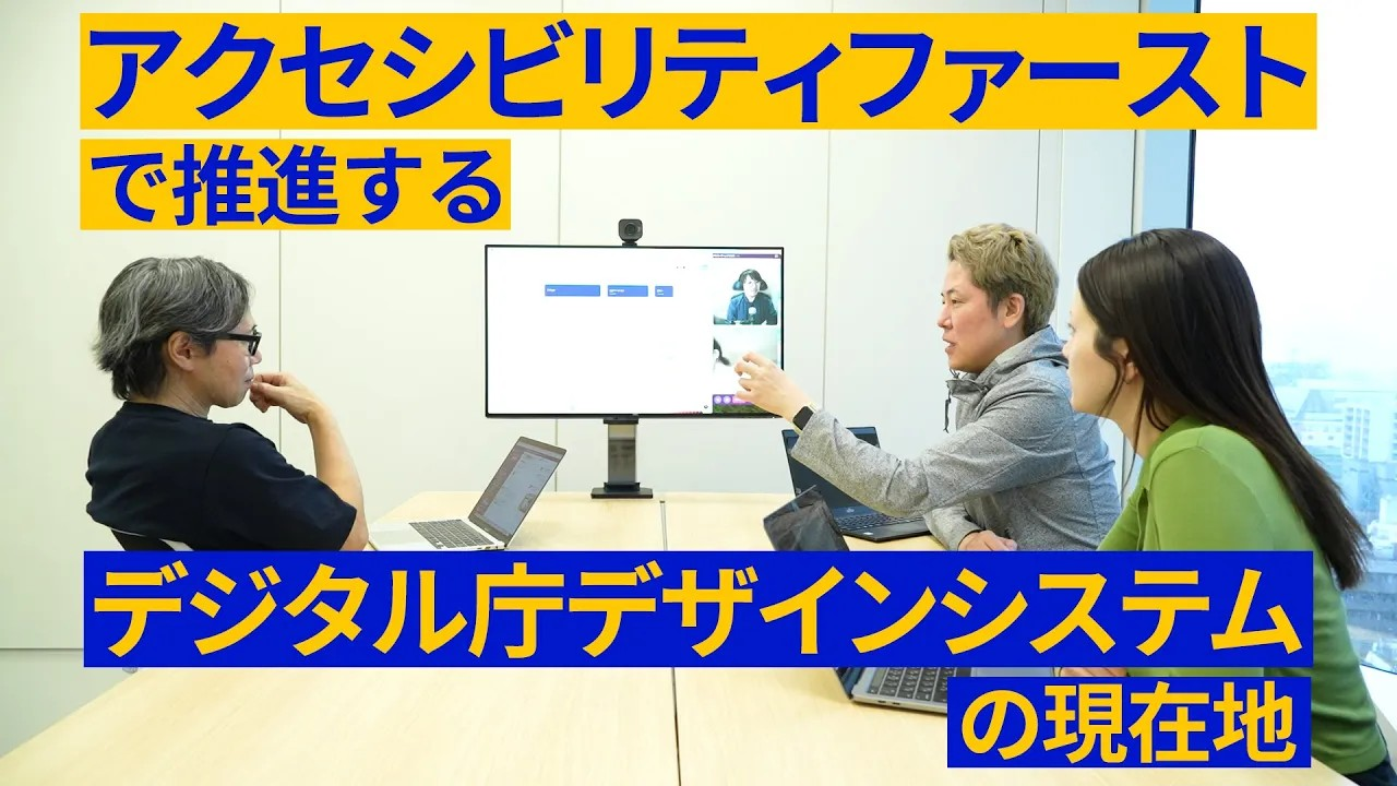 PCを前に打ち合わせをするデジタル庁のデザイナー3人。左には眼鏡をかけた黒いTシャツを着た男性、右奥には金髪のグレーのパーカーを着た男性、右手前には緑のトップスを着たロングヘアの女性が写っている。