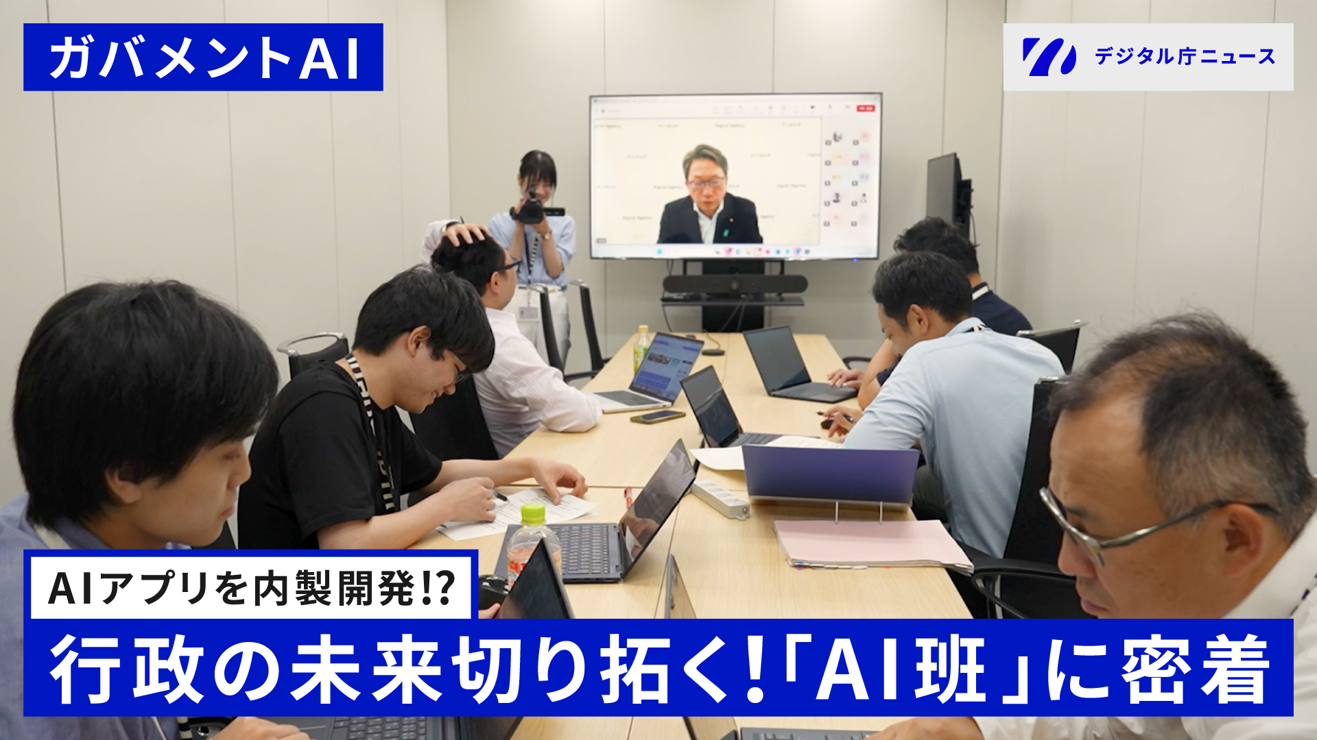 デジタル庁のAI班のメンバーが会議室に集まり、モニターに映る大臣会見を見ている様子の写真。左上に「ガバメントAI」、下部に「AIアプリを内製開発！？行政の未来切り拓く！「AI班」に密着」のテキスト。左上には、デジタル庁ニュースロゴ。