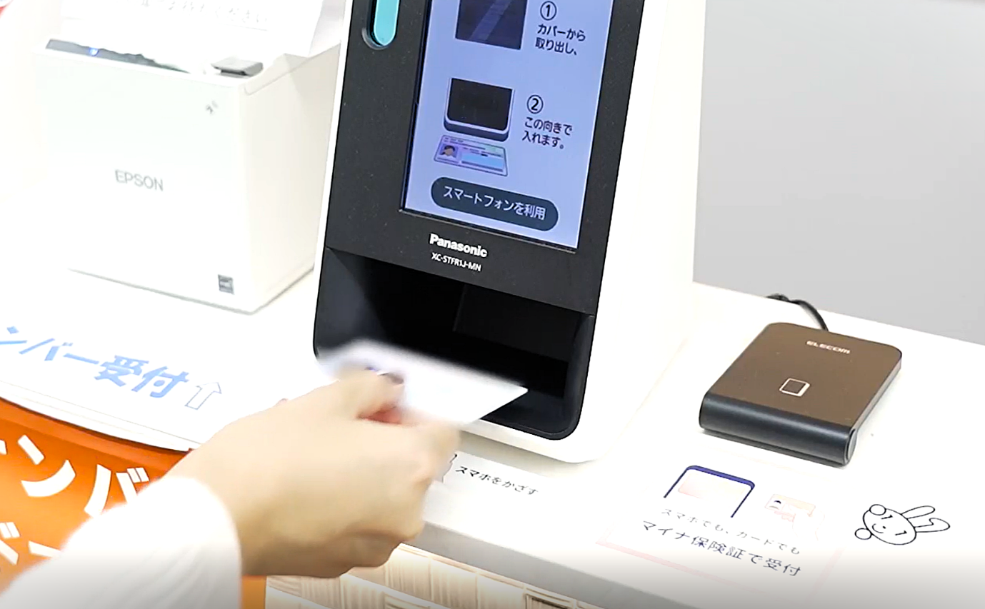 マイナ保険証をカードリーダーにかざしている写真